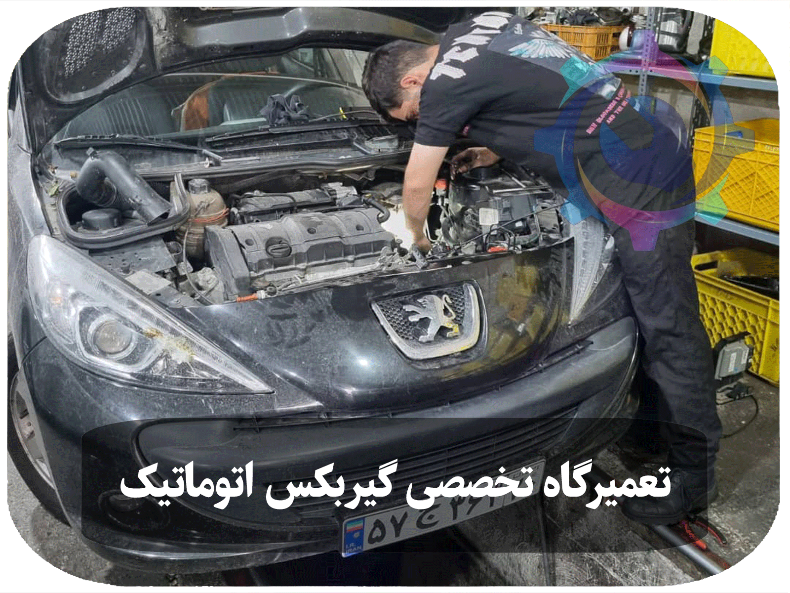 مکانیک در حال تعمیر گیربکس اتوماتیک خودروی پژو 207 در یک کارگاه تخصصی تعمیرات خودرو